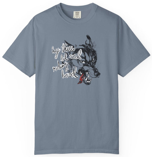 blue gray t-shirt on a white background  with graphic design of a wolf and the phrase "hey there little red riding hood."