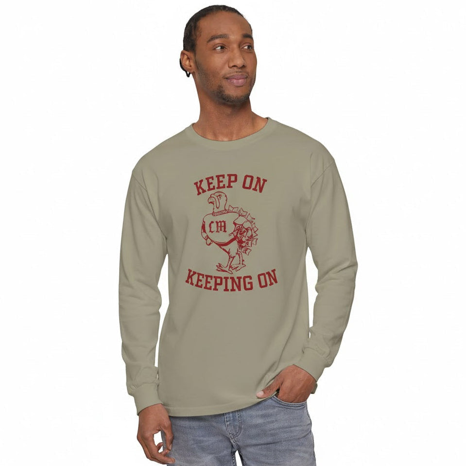 Man wearing a beige long-sleeve shirt with red graphic and text on a white background
