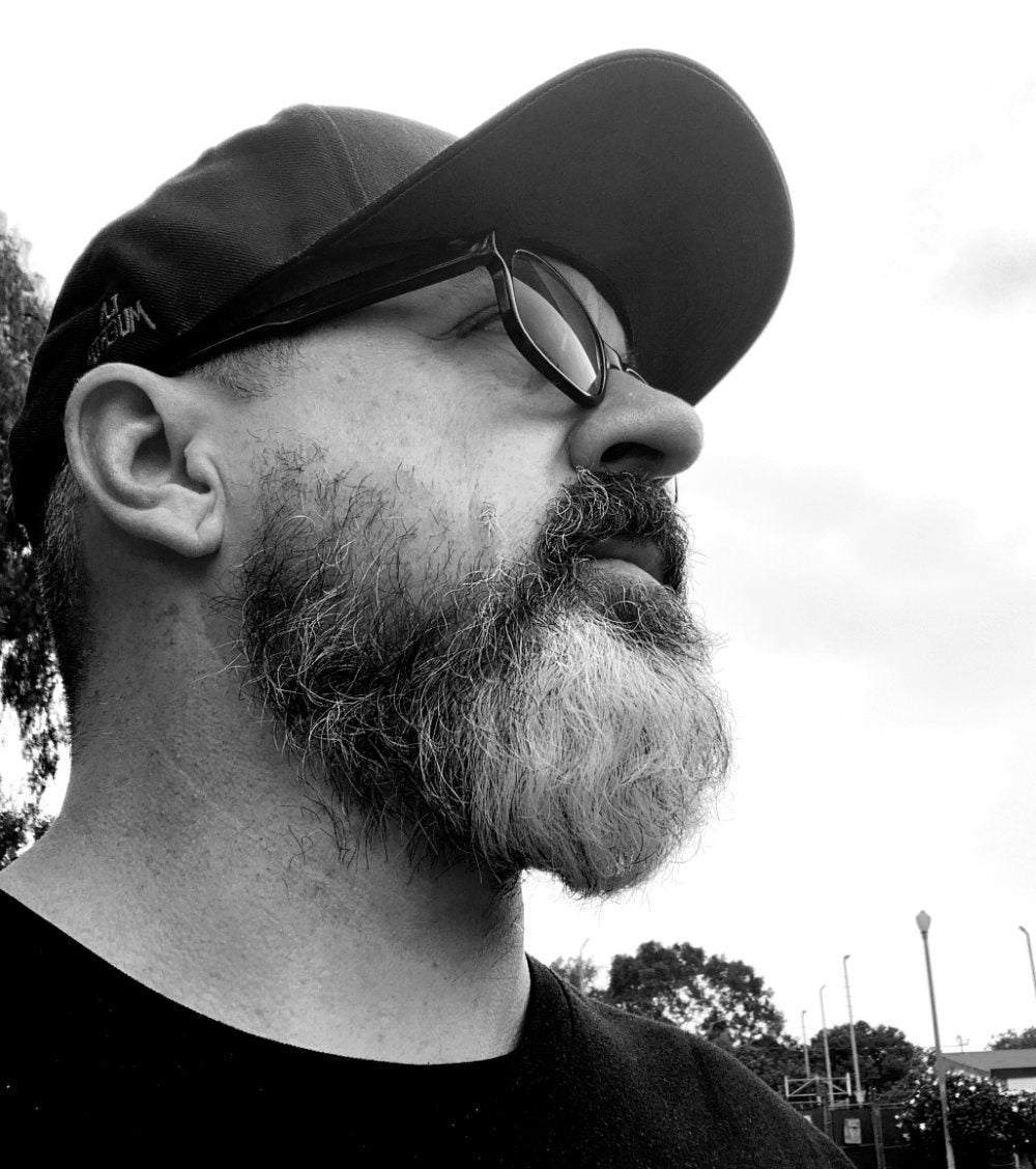dave conrey in a ball cap and glass in a side profile black and white photograph